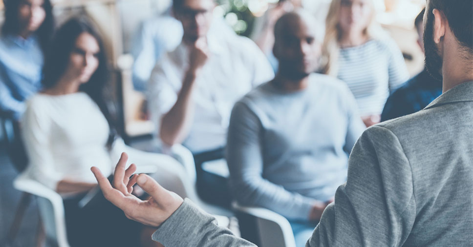 Palestrante dando início a uma apresentação de trabalho em uma reunião corporativa