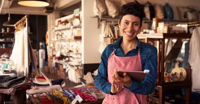 Mulher de avental em sua nova loja: veja como viver um empreendedorismo de sucesso